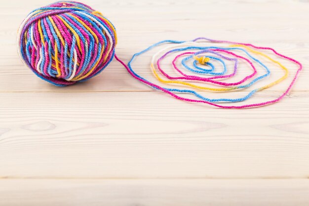 farebné klbká priadzí a ihličky na stole